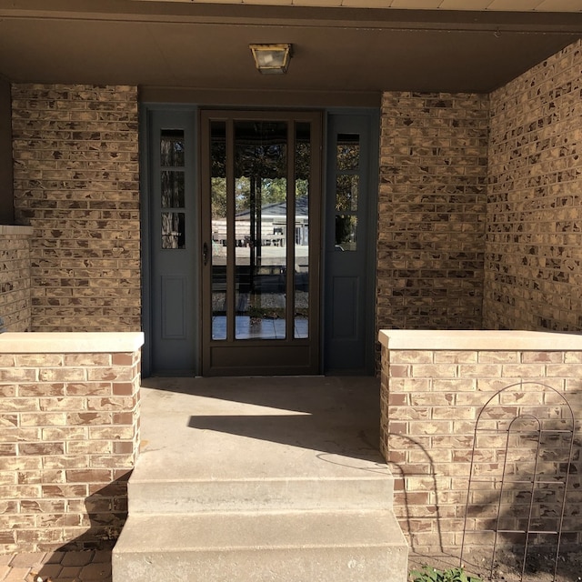 view of exterior entry with brick siding