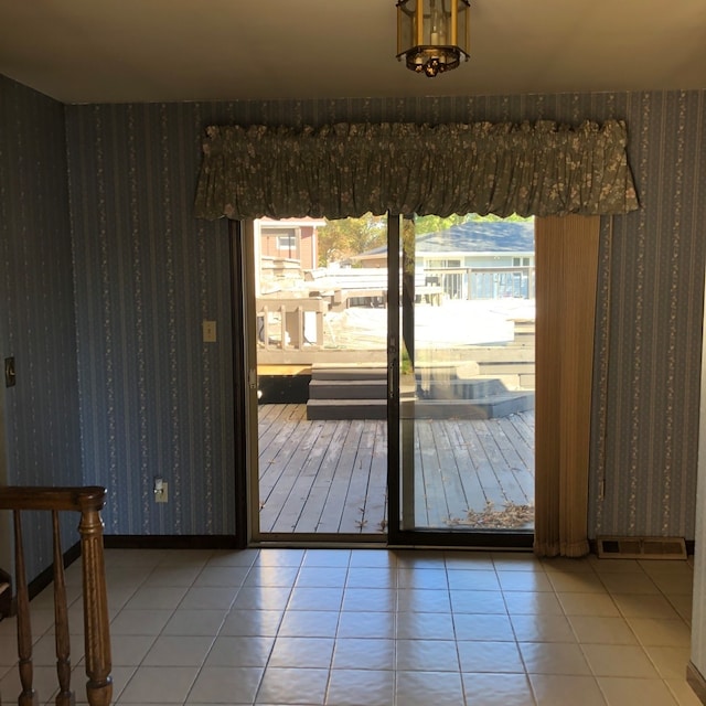 doorway to outside with tile patterned flooring