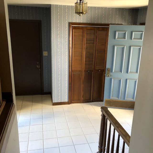 corridor featuring light tile patterned floors and a chandelier