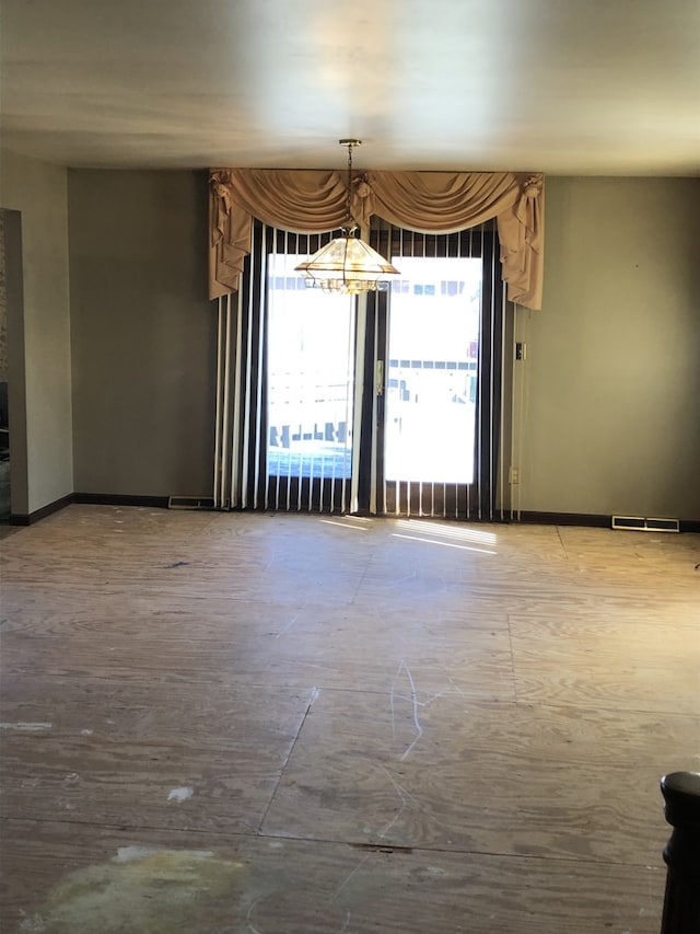 unfurnished room featuring a notable chandelier