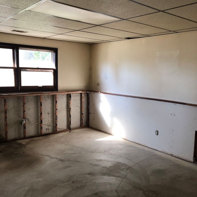 spare room with concrete flooring and a drop ceiling