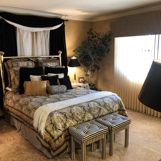 bedroom featuring light wood-type flooring and crown molding