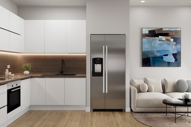 1342 W Wellington Ave, Chicago, IL 60657 - kitchen featuring wall oven, modern cabinets, stainless steel fridge, white cabinetry, and a sink