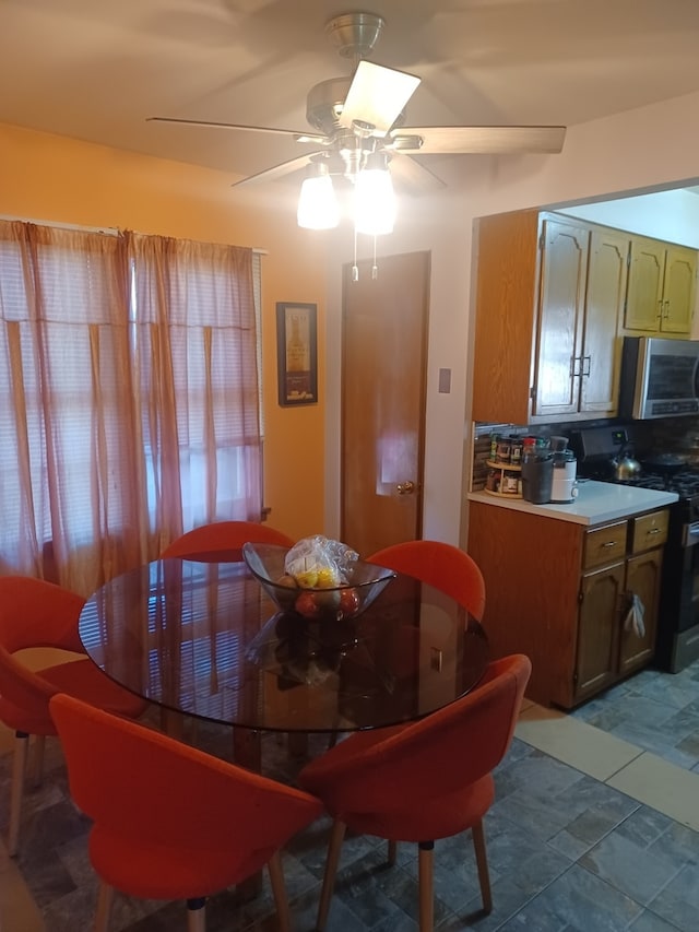 dining space with ceiling fan and tile patterned flooring