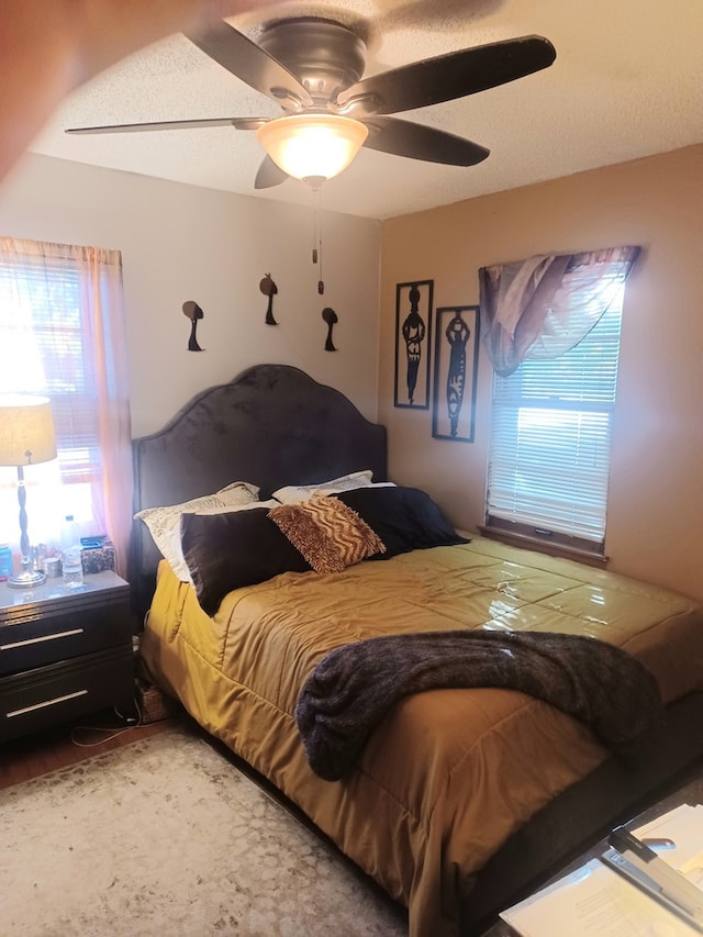 bedroom featuring a textured ceiling, hardwood / wood-style flooring, and ceiling fan