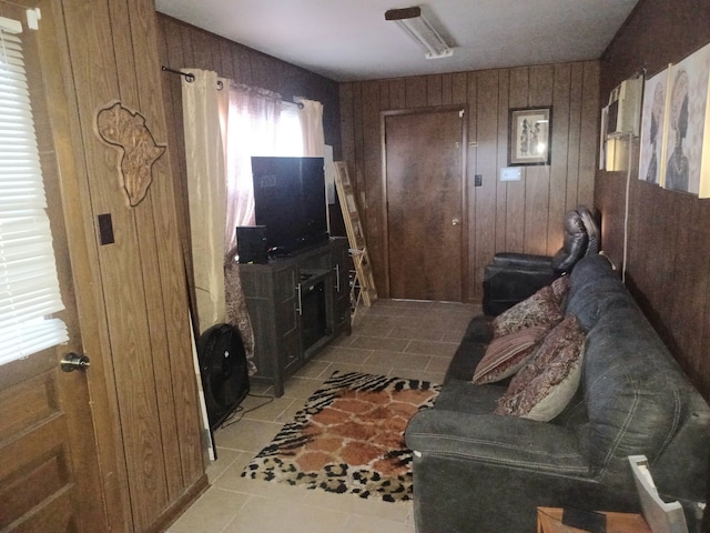 living room featuring light tile patterned flooring and wooden walls