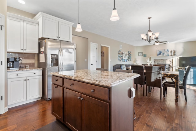 kitchen featuring stainless steel refrigerator with ice dispenser, white cabinets, decorative light fixtures, and dark wood-type flooring