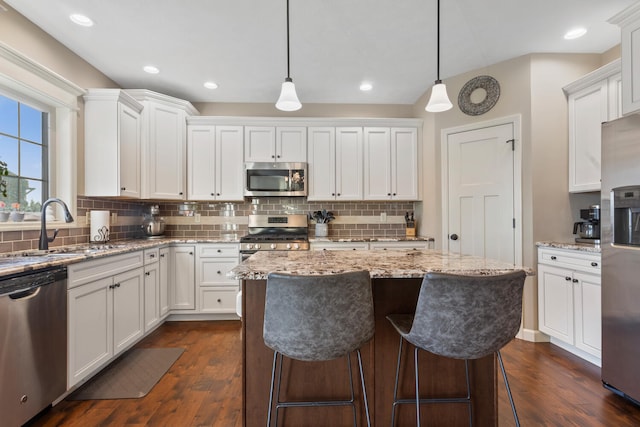 kitchen with pendant lighting, white cabinetry, dark wood-type flooring, and stainless steel appliances