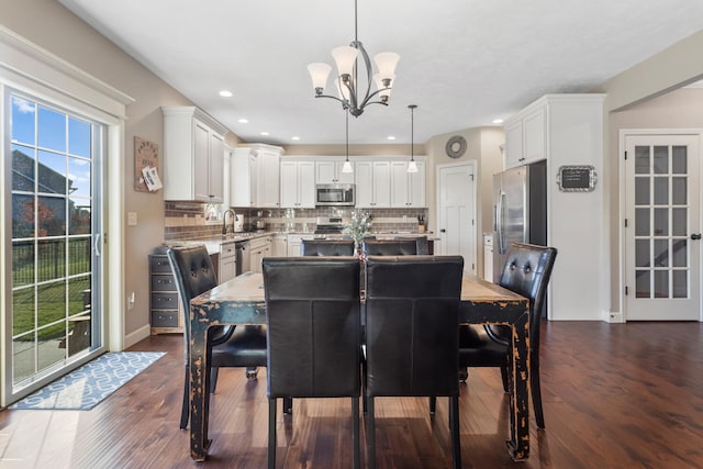 dining room with dark wood-type flooring and an inviting chandelier