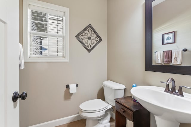 bathroom with toilet, sink, and tile patterned flooring