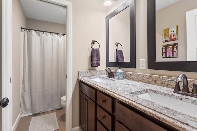 bathroom featuring tile patterned floors, toilet, a shower with curtain, vanity, and a textured ceiling