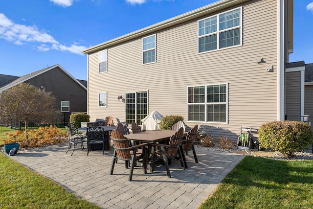 rear view of property featuring a patio area and a lawn