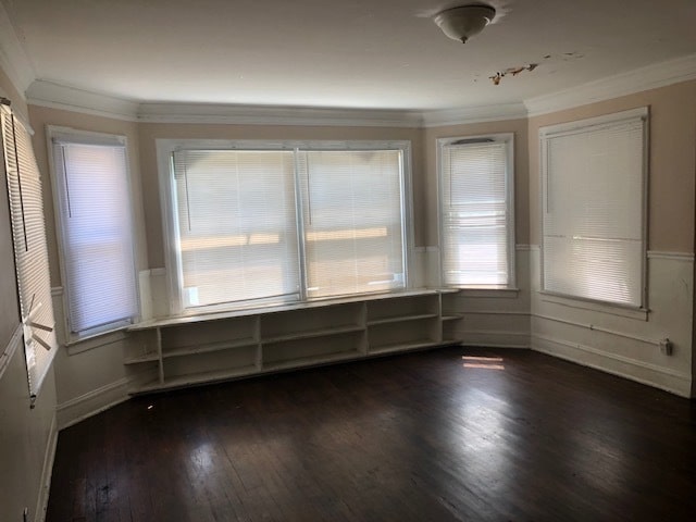 unfurnished dining area featuring crown molding and dark hardwood / wood-style flooring