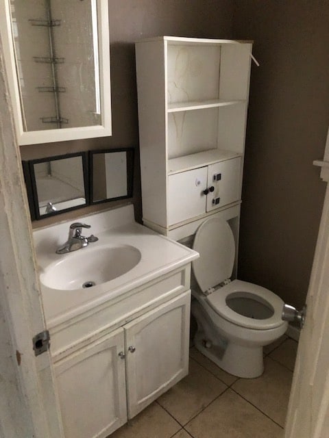 bathroom with vanity, toilet, and tile patterned flooring