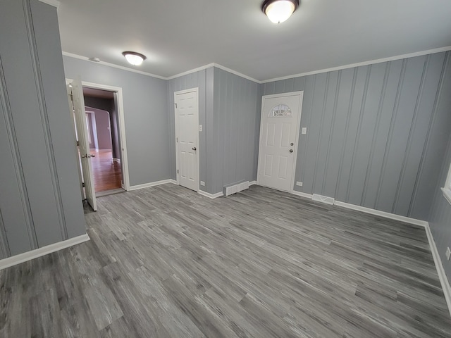 empty room featuring light hardwood / wood-style flooring and ornamental molding