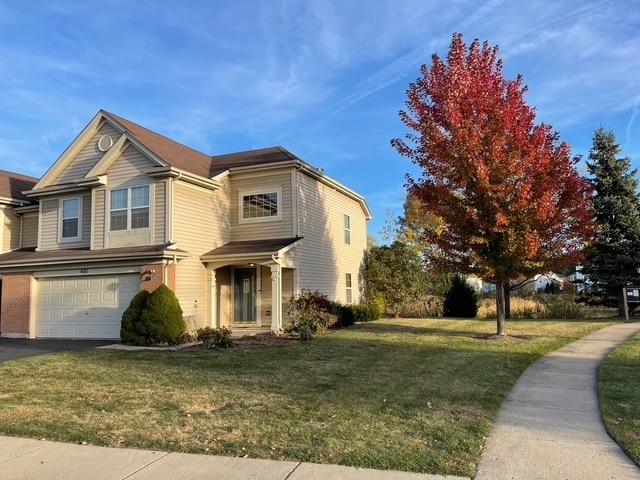 view of front of property with a garage and a front lawn