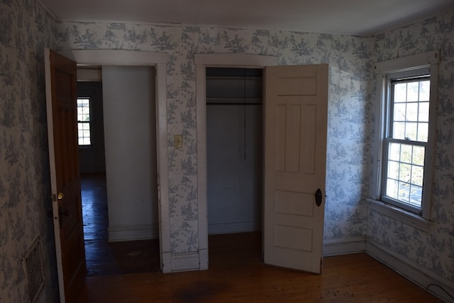 unfurnished bedroom with a closet and dark hardwood / wood-style floors