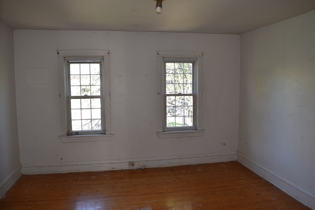 spare room featuring wood-type flooring and plenty of natural light