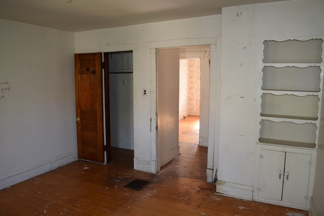 unfurnished bedroom featuring dark hardwood / wood-style floors and a closet