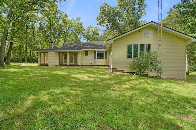 rear view of house featuring a lawn