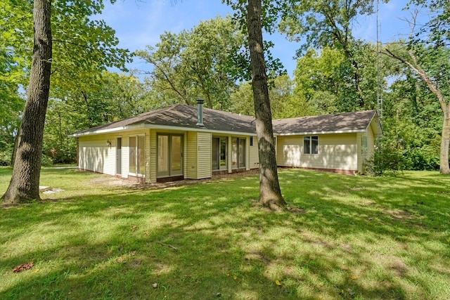 rear view of property with a yard