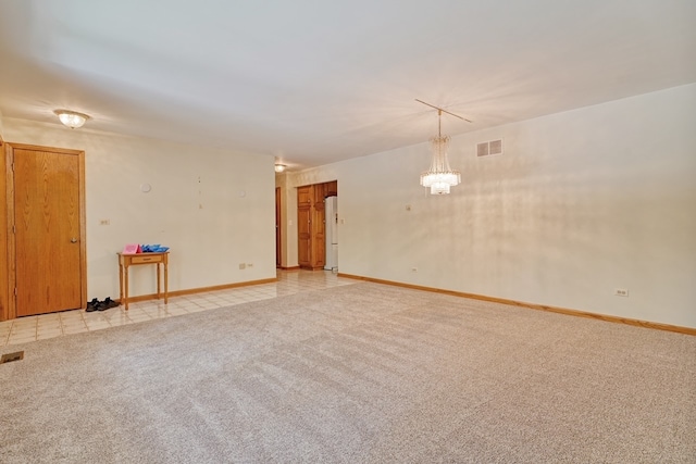 carpeted spare room featuring a notable chandelier