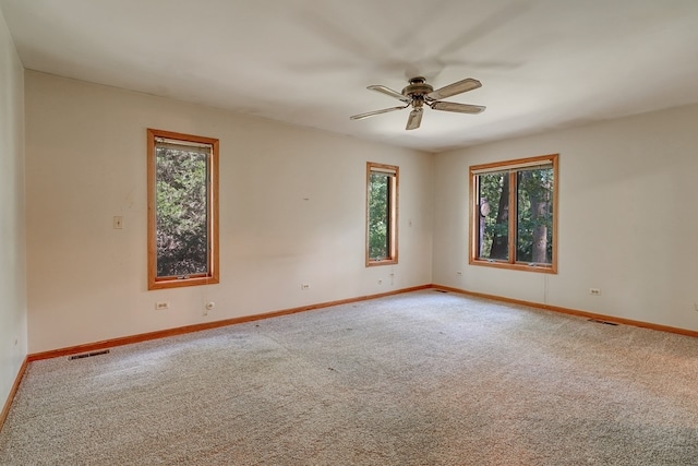 carpeted spare room featuring ceiling fan