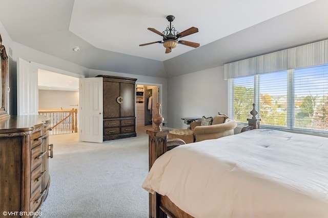 carpeted bedroom with a raised ceiling and ceiling fan