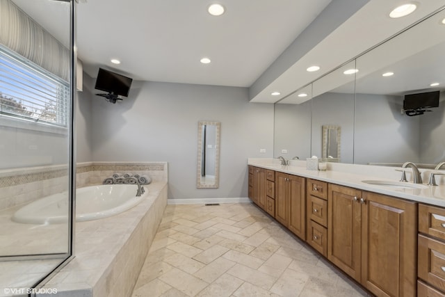 bathroom featuring vanity and tiled bath