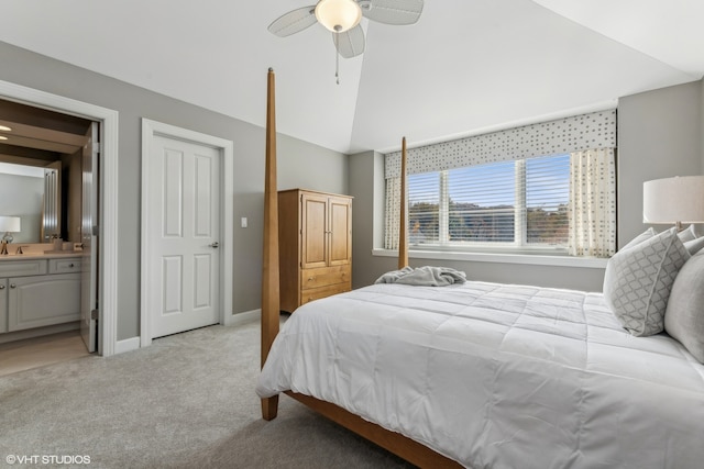 carpeted bedroom featuring ceiling fan, ensuite bathroom, and lofted ceiling