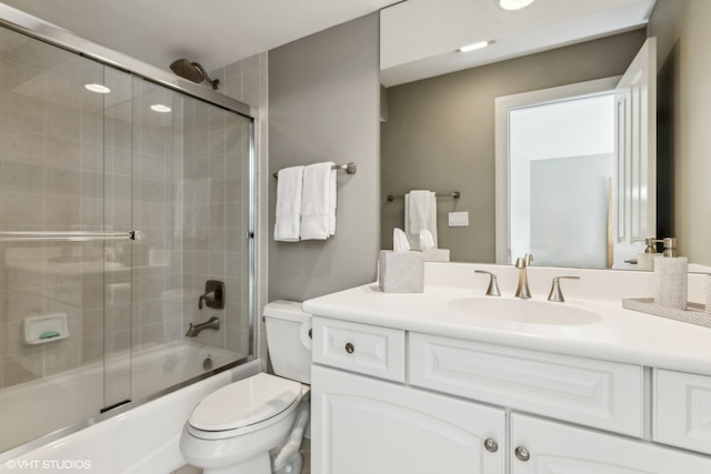 full bathroom with shower / bath combination with glass door, vanity, and toilet