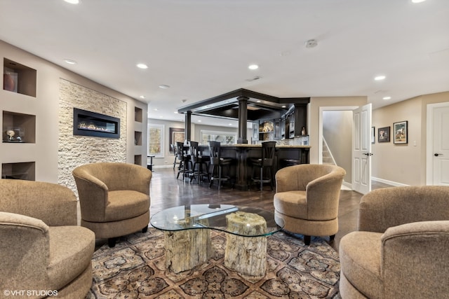 living room with bar area and dark hardwood / wood-style flooring