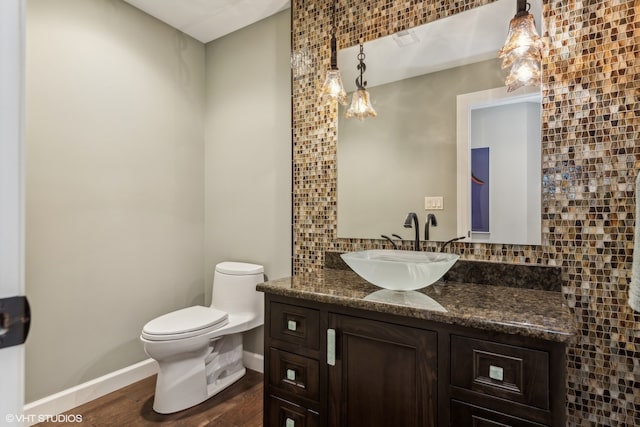 bathroom featuring tasteful backsplash, toilet, vanity, and hardwood / wood-style flooring