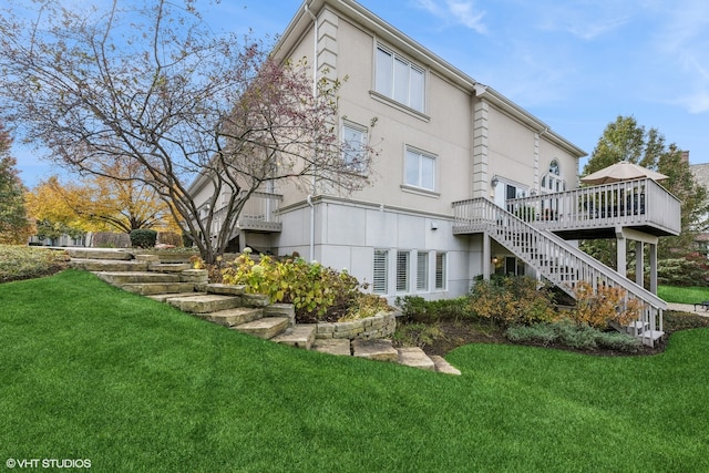 back of property featuring a lawn and a wooden deck