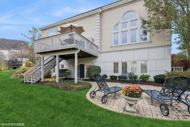 back of property featuring a lawn, a patio area, and a deck