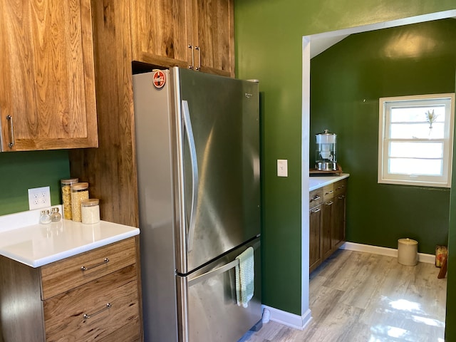 kitchen with light hardwood / wood-style floors and stainless steel refrigerator