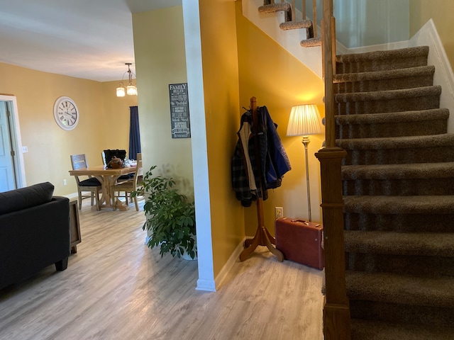 stairway with a notable chandelier and hardwood / wood-style floors