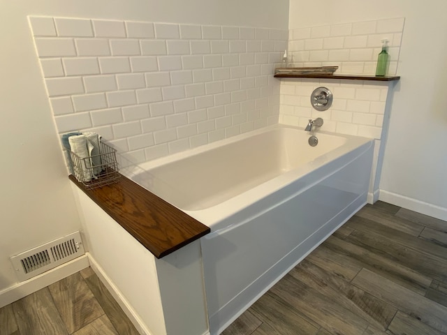 bathroom featuring hardwood / wood-style floors and a bath