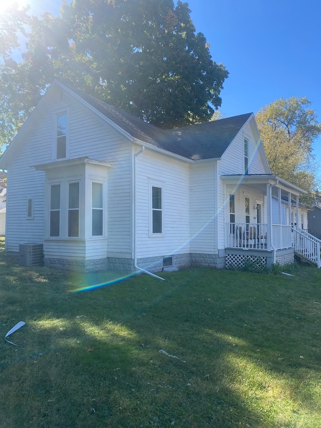 exterior space with central air condition unit, a lawn, and a porch