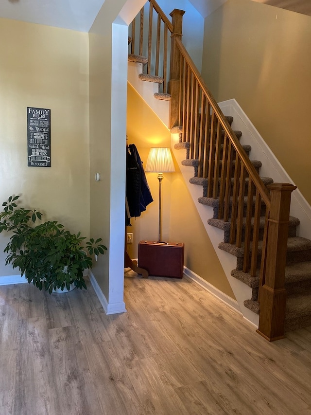 staircase with hardwood / wood-style floors