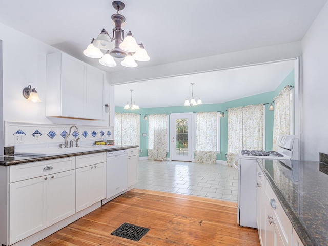 kitchen featuring white appliances, visible vents, decorative light fixtures, white cabinetry, and a notable chandelier