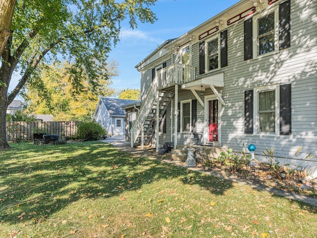 view of front of house featuring stairs, a front yard, and fence