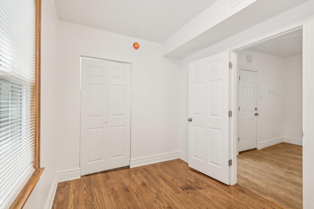 unfurnished bedroom with a closet and hardwood / wood-style floors