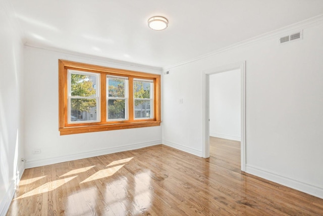 unfurnished room with crown molding and light wood-type flooring