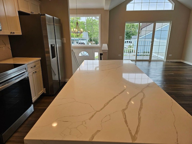 kitchen featuring white cabinetry, light stone countertops, electric range, a chandelier, and decorative light fixtures