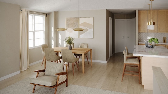 dining area with light wood-type flooring and a healthy amount of sunlight