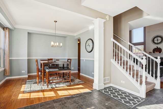 dining room with dark hardwood / wood-style flooring, decorative columns, an inviting chandelier, and plenty of natural light