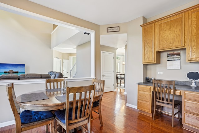 dining area with built in desk and dark wood-type flooring