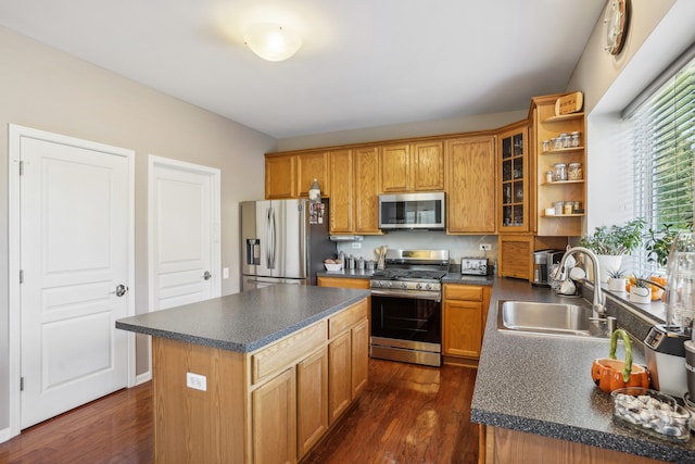 kitchen featuring sink, a kitchen island, appliances with stainless steel finishes, and dark hardwood / wood-style floors