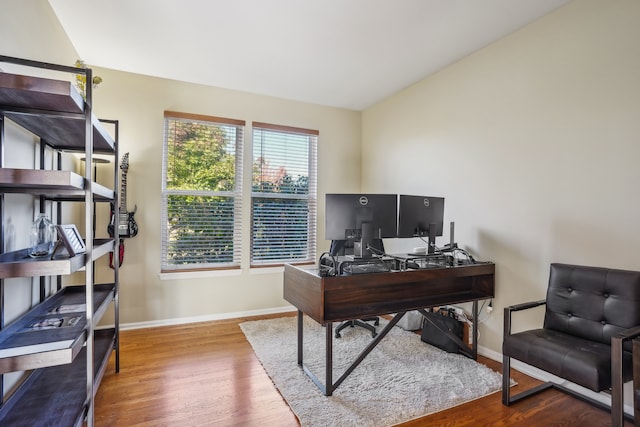 office featuring lofted ceiling and hardwood / wood-style flooring